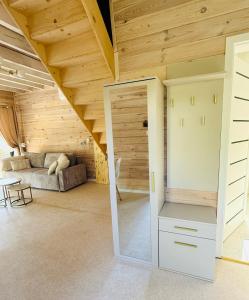 ein Wohnzimmer mit einer Couch und einer Tür in einem Zimmer in der Unterkunft Venice barn Przełazy in Przełazy + 14 Fotos