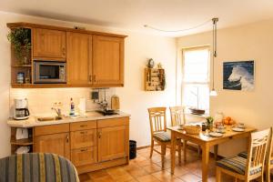 a kitchen with wooden cabinets and a table with chairs at Apartmenthaus Ostseewelle Ferienwohnung 13 in Kühlungsborn +6 photos