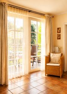 a living room with a chair and a sliding glass door at Apartmenthaus Ostseewelle Ferienwohnung 13 in Kühlungsborn