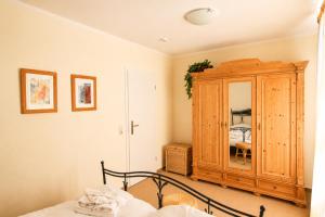 a bedroom with a wooden cabinet and a bed at Apartmenthaus Ostseewelle Ferienwohnung 13 in Kühlungsborn