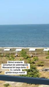 a sign in front of a beach with the ocean at Terras Astara in Astara