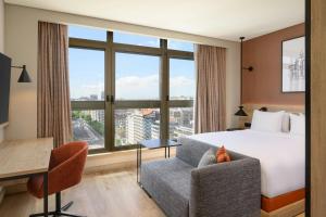 a hotel room with a bed and a chair and a desk at Residence Inn Lisbon by Marriott Hotel in Lisbon