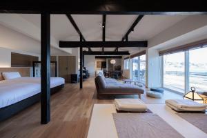 a bedroom with a bed and a couch in a room at marinoe organic resort - Health and Stay - A Private Lakeside Villa at Lake Yamanaka, Blessed by the Spirit of Mount Fuji in Yamanakako