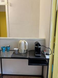 a table with a coffee maker and a toaster on it at Soleil in Villejuif