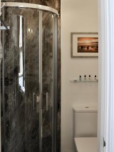 a shower with a glass door in a bathroom at The Florence Guest House in Whitby