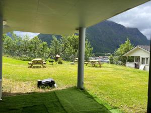 a picnic area with picnic tables and mountains in the background at Åndalsnes house in Åndalsnes