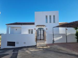 a white house with a gate in front of it at villa piscina y vistas espectaculares a la montana , gran terraza y aire acondicionado in Cuevas del Almanzora