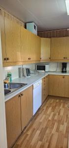a kitchen with wooden cabinets and white appliances at Nord Hus 3 in Loppa