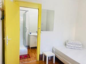 a bedroom with a yellow door leading to a bathroom at Soleil in Villejuif