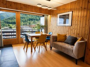 a living room with a couch and a table with chairs at Vue Alpes imprenable - Centre - 4 Vallées in Nendaz