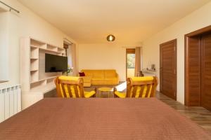 a living room with a table and chairs and a couch at Zvjezdana dolina Garni hotel in Andrijevica