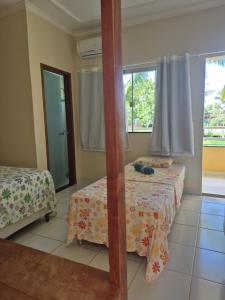a bedroom with two beds and a mirror at Pousada Elshadai in Uruçuca