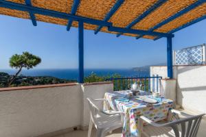 a table and chairs on a balcony with a view of the ocean at Bel Horizonte 7 in Capoliveri