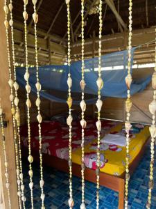 a bunk bed with gold chains on it at Mentawai Tribe Experience & Private Beach Camp in Pulau Masilo