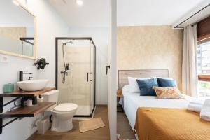 a bathroom with a bed and a shower and a sink at Emarooms Boutique Laredo in Laredo +69 photos