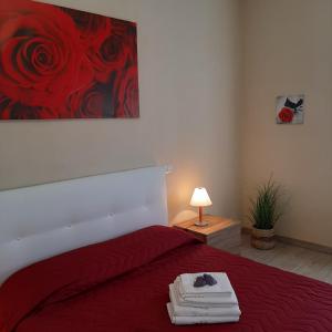 a bedroom with a red bed with a painting on the wall at Tuscany Hills - Comfort 10 minutes from Montepulciano and Pienza in Torrita di Siena