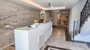 a lobby with a stone wall with a counter at As Hotel Cesme in Çeşme