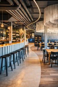 ein Restaurant mit Tischen und Stühlen und einer Bar in der Unterkunft Eringer Hotel in Hérémence