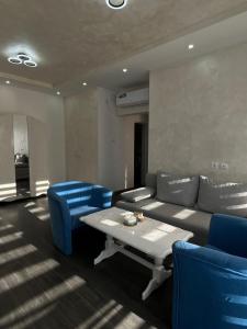 a living room with a couch and blue chairs at Apartman Nastić in Lazarevac