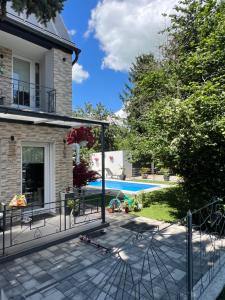 a patio with a fence in front of a house at Pool & Chill Balaton in Balatonvilágos