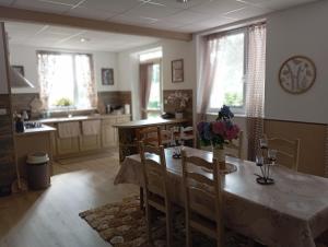 a kitchen with a table and chairs in a room at La Planoise in Autun