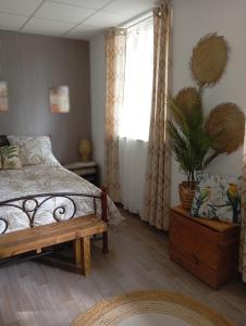 a bedroom with a bed and a potted plant at La Planoise in Autun