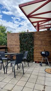 a patio with a table and chairs and a grill at HollidayVillage 5B in Matka Božia