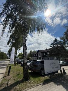 a car parked in a parking lot next to a tree at Gosciniec Pod Brzozami in Poznań