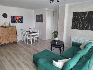 a living room with a green couch and a table at Cozy apartment! in Floreşti