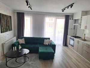 a living room with a green couch and a table at Cozy apartment! in Floreşti