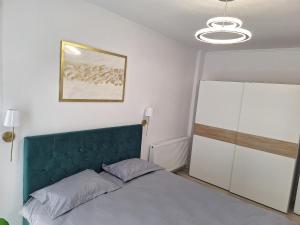 a bedroom with a bed and a white cabinet at Cozy apartment! in Floreşti