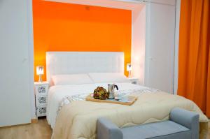 1 dormitorio con 1 cama grande y pared de color naranja en Oscar Apartments Estación, en Sitges