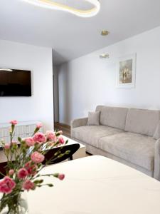 a living room with a couch and a table with flowers at Stella APART Resort & SPA in Władysławowo