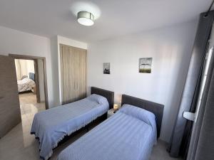 a room with two beds with blue sheets in it at villa piscina y vistas espectaculares a la montana , gran terraza y aire acondicionado in Cuevas del Almanzora +53 photos