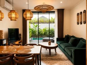a living room with a green couch and a table at Village Berawa in Badung