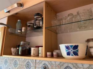 a cupboard with dishes and glasses on it at Ferienwohnung Zum Bachsee in Chorin +30 photos