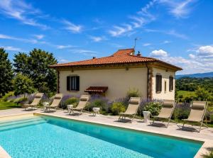 a villa with a swimming pool in front of a house at Villa La Gioconda - Heated Pool and Gym in Arezzo