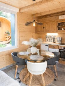 a dining room with a table and chairs in a kitchen at CHALET COSY A LA MONTAGNE AVEC SAUNA TONNEAU situé à St Laurent en Grandvaux - Proche lacs cascades et pistes de ski in Saint-Laurent-en-Grandvaux