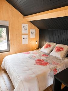 a bedroom with a large bed with red flowers on it at CHALET COSY A LA MONTAGNE AVEC SAUNA TONNEAU situé à St Laurent en Grandvaux - Proche lacs cascades et pistes de ski in Saint-Laurent-en-Grandvaux