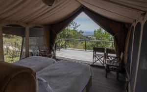 a tent with two beds and a view of a porch at Posho Sunset Mara in Sekenani