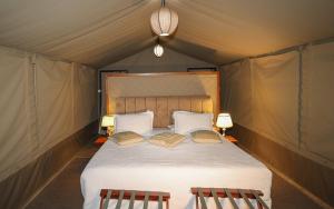 a bedroom with a bed in a tent at Posho Sunset Mara in Sekenani