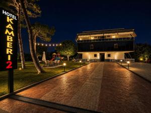 a building with a sign in front of it at night at Kamberi Hotel & Apartments 2 in Velipojë