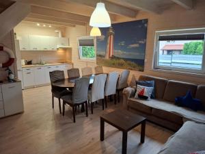 a kitchen and a dining room with a table and chairs at Domek nad morzem Jerzyk 506-385-791 in Stegna