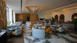 a dining room with tables and chairs in a restaurant at Dragon Beach Hotel in Manama