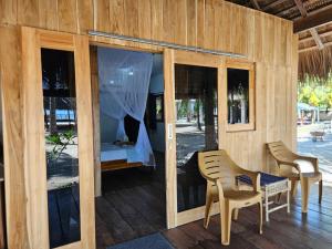 a room with a bed and a table and chairs at Belar Reef Bungalows in Nembrala