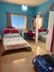 a bedroom with a bed and a desk and a mirror at appartement chaleureux in Oran