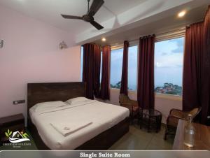 a bedroom with a bed and a large window at Greenleaf Holidays in Munnar