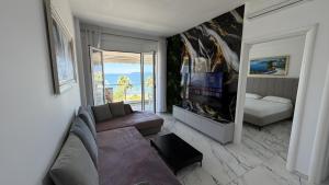 a living room with a couch and a television at Jimi Apartments in Vlorë