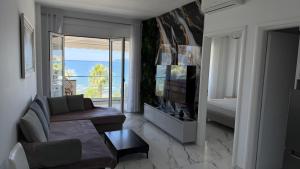 a living room with a couch and a view of the ocean at Jimi Apartments in Vlorë