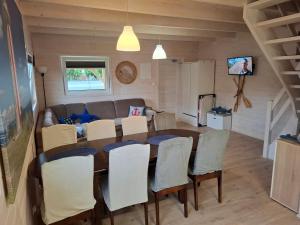 a dining room and living room with a table and chairs at Domek nad morzem Jerzyk 506-385-791 in Stegna
